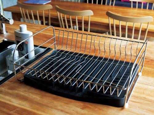 a metal wire rack on a table with chairs at CHULAX OKINAWA YOMITAN【Designer Condominium Hotel】 in Yomitan