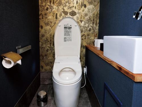 a bathroom with a white toilet and a sink at CHULAX OKINAWA YOMITAN【Designer Condominium Hotel】 in Yomitan