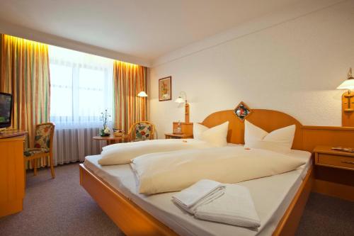 a hotel room with two beds and a television at Hotel Mayerhofer in Aldersbach