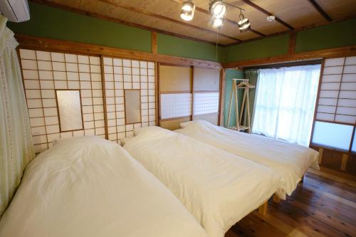 two beds in a room with green walls and windows at Ichiya - Vacation STAY 83331 in Shimosato