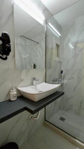 a white bathroom with a sink and a shower at EPaN Luxury Apartments in Thessaloniki
