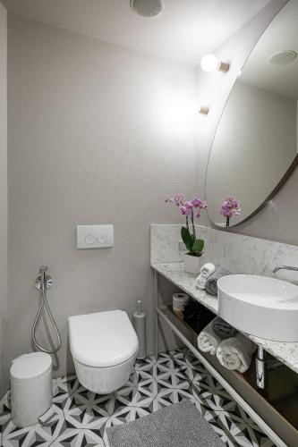 a bathroom with a toilet and a sink and a mirror at Redstone Apartments in Rīga