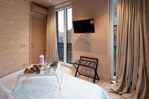 a bedroom with a bed and a table with a candle at Redstone Apartments in Rīga