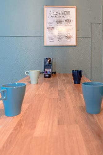 a wooden table with blue cups on top of it at CATTENOM NEW NOVÝ NOWY НОВИЙ - 3 min Parking, Wi-Fi, Nespresso - Repos assuré, calme & confort - Rest guaranteed, quiet & comfy in Hayange