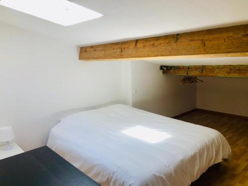 - une chambre avec un lit blanc et un plafond en bois dans l'établissement Duplex La Ciotat - superbe 85 m2 - 6 pers - 3 chambres - Climatisation - Vue mer et proche du vieux port La Ciotat, à La Ciotat