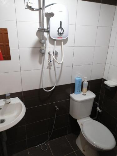 a bathroom with a shower and a toilet and a sink at StarVilla Kinta River Front Medan Istana in Ipoh