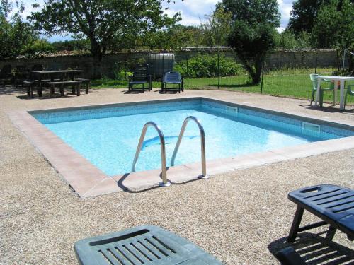 a swimming pool with two chairs and a table at Columba - Les Constellations in Doeuil-sur-le-Mignon