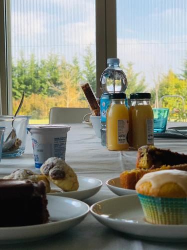 a table with plates of food and bottles of orange juice at B&B Beauty House in Cesena