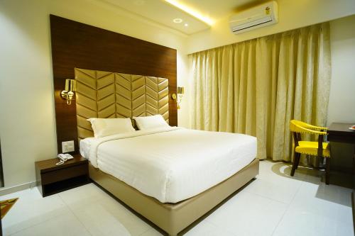 a bedroom with a large bed and a desk at Orange Tree Hotels in Nagpur