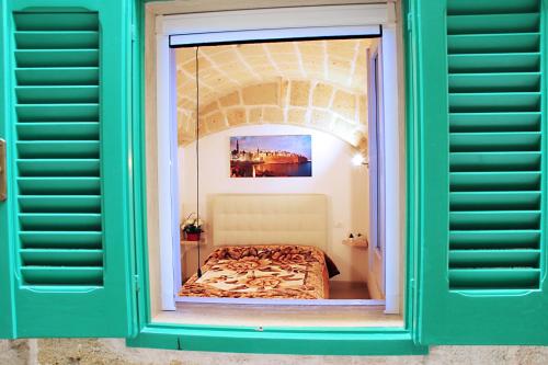 ventana con cama en una habitación en La casetta del cuore, en Monopoli