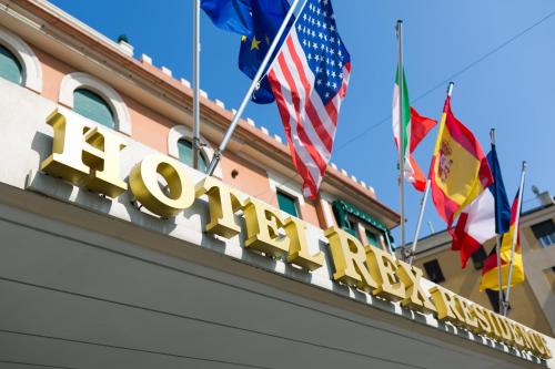 una señal para el hotel la torre frente a las banderas en Rex Hotel Residence, en Génova