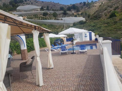 a patio with chairs and umbrellas next to a pool at A867 - La Rodeta in Callosa de Ensarriá