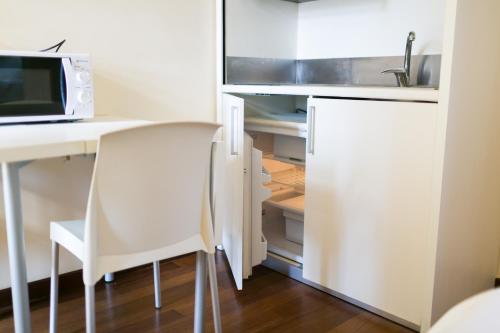 an open kitchen with a desk and a microwave at Rex Hotel Residence in Genova