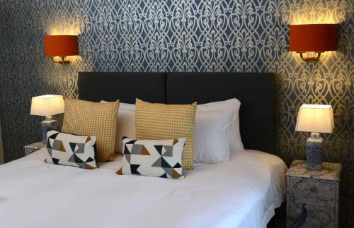 1 dormitorio con 1 cama con almohadas y 2 lámparas en The Kings Head Inn, en Billingshurst