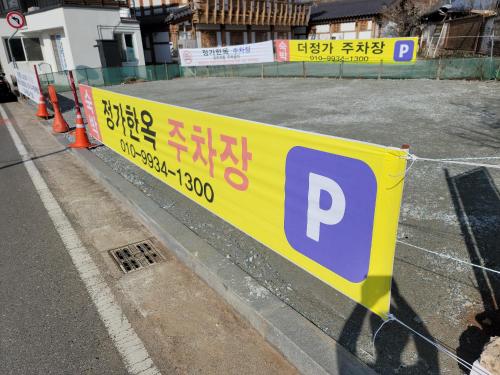 a yellow parking sign on the side of a street at The Jeongga in Jeonju