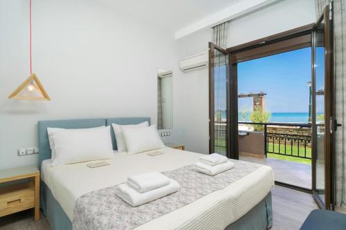 een slaapkamer met een bed en uitzicht op de oceaan bij Kamelia & Semeli Hotel in Skala Potamias