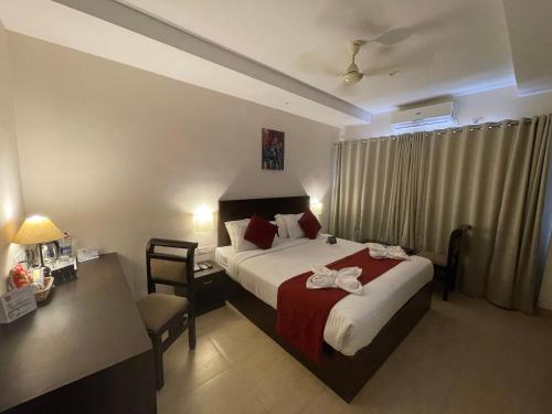 a hotel room with a bed and a desk and a bed sidx sidx sidx sidx at Hotel Yamuna in Adūr