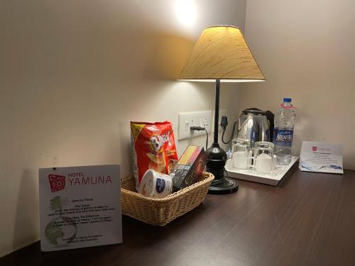 a table with a basket of food and a lamp on it at Hotel Yamuna in Adūr