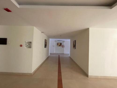 a long hallway with white walls and a red stripe on the floor at Hotel Yamuna in Adūr