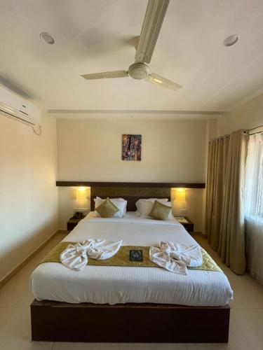 a bedroom with a large bed with towels on it at Hotel Yamuna in Adūr