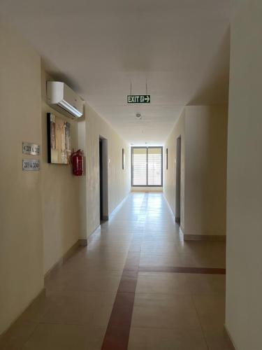 an empty hallway in a building with a sign on the ceiling at Hotel Yamuna in Adūr