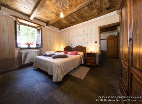 een slaapkamer met een bed met kussens erop bij Il Casolare Bioenergetico in Albareto