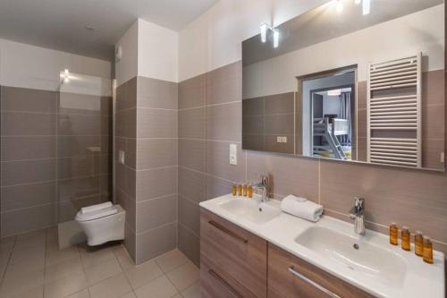 une salle de bain avec un lavabo, des toilettes et un miroir dans l'établissement The View - Apt 15 - BO Immobilier - Châtel, à Châtel