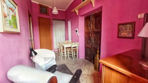 a pink room with a chair and a table at Casa Filomena in Morano Calabro