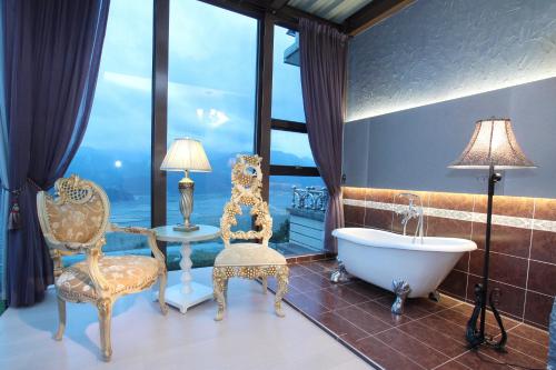 a bathroom with a tub and a table and chairs at Hao Wang Jiao House in Datong