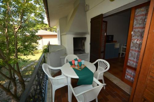 - Balcón con mesa blanca y sillas en Lignano Riviera, en Lignano Sabbiadoro