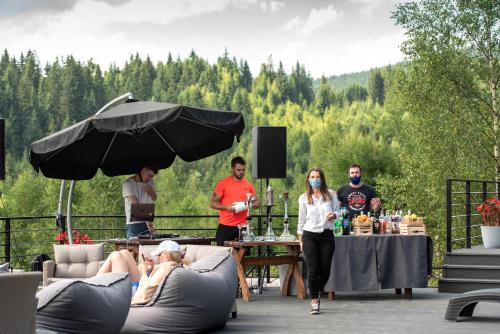 a group of people standing on a patio with a table at Stara Pravda Hotel - Vykrutasy in Bukovel