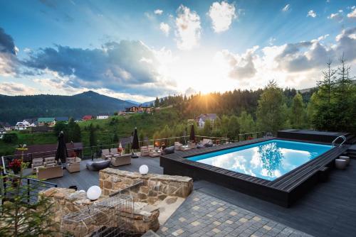 a pool on a patio with a view of the mountains at Stara Pravda Hotel - Vykrutasy in Bukovel