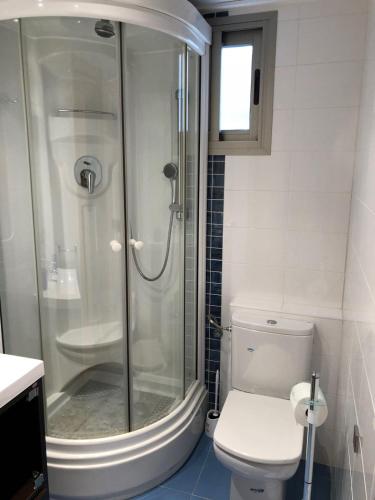 a white bathroom with a shower and a toilet at Playa Norte 7ºG in Peniscola