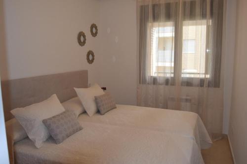 a bedroom with a white bed and a window at La Caparina, apartamento con piscina a 3 km de la playa VUT-2377-AS in Llanes