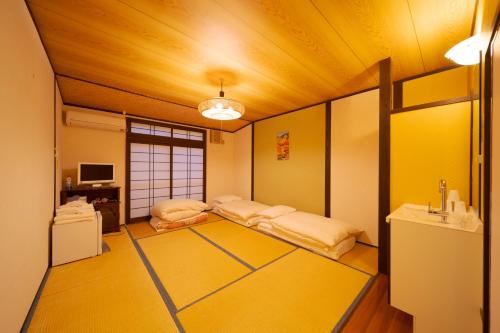 two beds in a room with yellow walls at David no Yakata in Yufuin