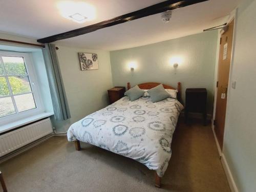 een slaapkamer met een bed en een raam bij The Harp Inn in Glasbury