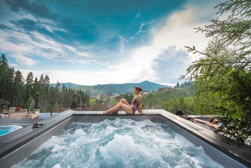 a woman sitting in a jacuzzi in a pool at Stara Pravda Hotel in Bukovel
