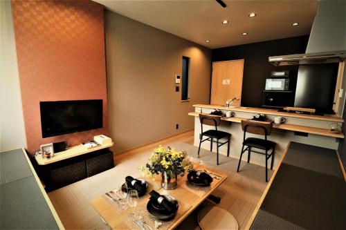 a living room with a table and a kitchen at ORIGAMI STAY -Futatsubashicho- in Nagoya