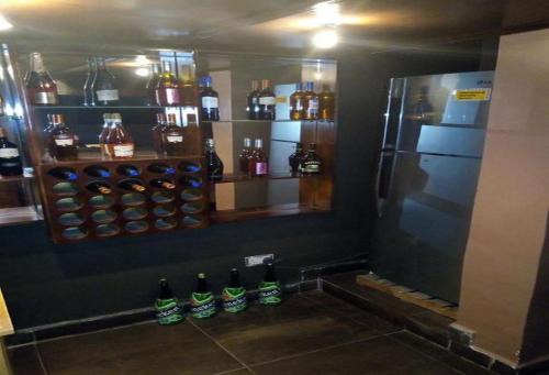 a bar with a refrigerator and a bunch of bottles at Allure Suites - Luxury Room in Surulere