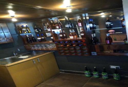 a bar with a lot of bottles of alcohol at Allure Suites - Luxury Room in Surulere