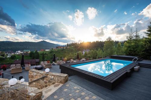 a pool on a patio with a view of the mountains at Stara Pravda Hotel in Bukovel