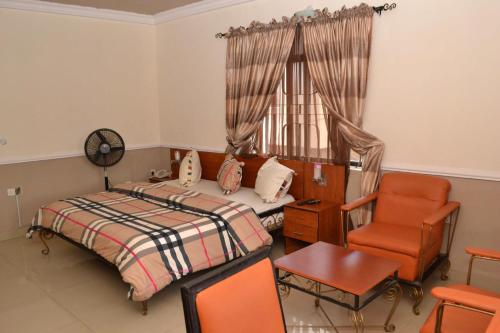 Suru LereにあるRoom in Lodge - Aquatic Suites Loungeのベッドルーム1室(ベッド1台、椅子、窓付)