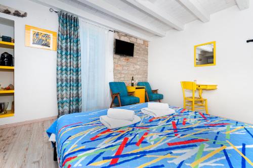 a bedroom with a large bed with colorful chairs at Apartments & Rooms La casa Barbaro in Rovinj
