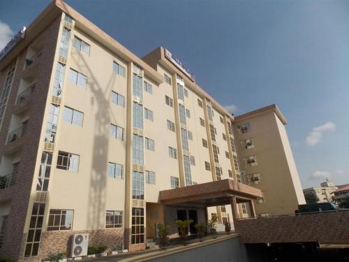 a large apartment building with a parking lot at Ayalla Hotels now Elomas Hotel-Executive in Abuja