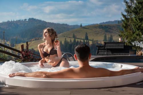 a man and a woman sitting in a bath tub at Stara Pravda Hotel in Bukovel