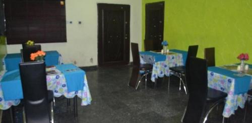 a room with blue tables and chairs and a green wall at Blueseasons Hotel Suites - Standard in Surulere