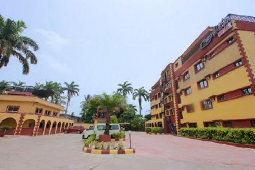 une rue avec des bâtiments et des palmiers dans une ville dans l'établissement Carliza Hotel - Standard, à Lagos