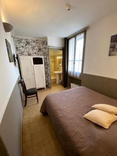 une chambre avec un grand lit et une salle de bain dans l'établissement Hôtel Restaurant Le Saint Gillois, à Saint-Gilles