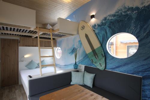 Zimmer mit einem Surfbrett-Wandbild an der Wand in der Unterkunft Tiny Wave Tiny House auf dem Campingplatz Strandgut in Cuxhaven