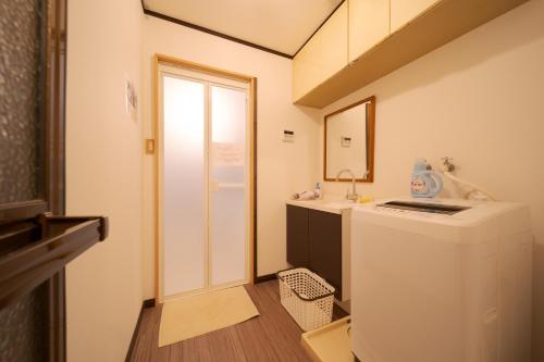 a small bathroom with a sink and a refrigerator at David no Yakata in Yufuin